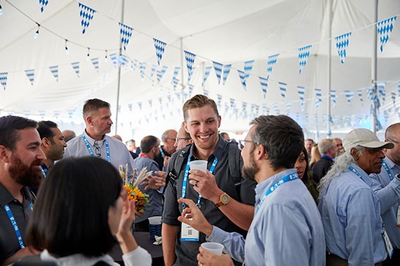 A lively party scene with people laughing, dancing, and enjoying drinks together in The Battery Show welcome reception